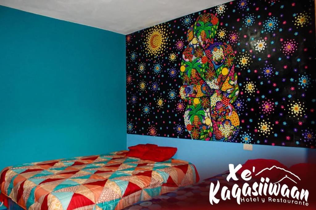 a bedroom with a painting on the wall at Xe 'Gakasiiwaan in San Juan La Laguna