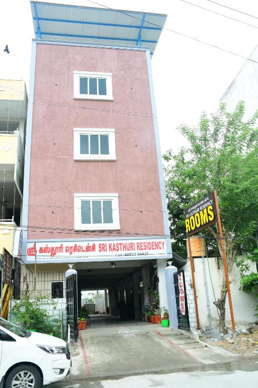 een rood bakstenen gebouw met een bord ervoor bij Sri KASTHURI Residency in Tiruttani