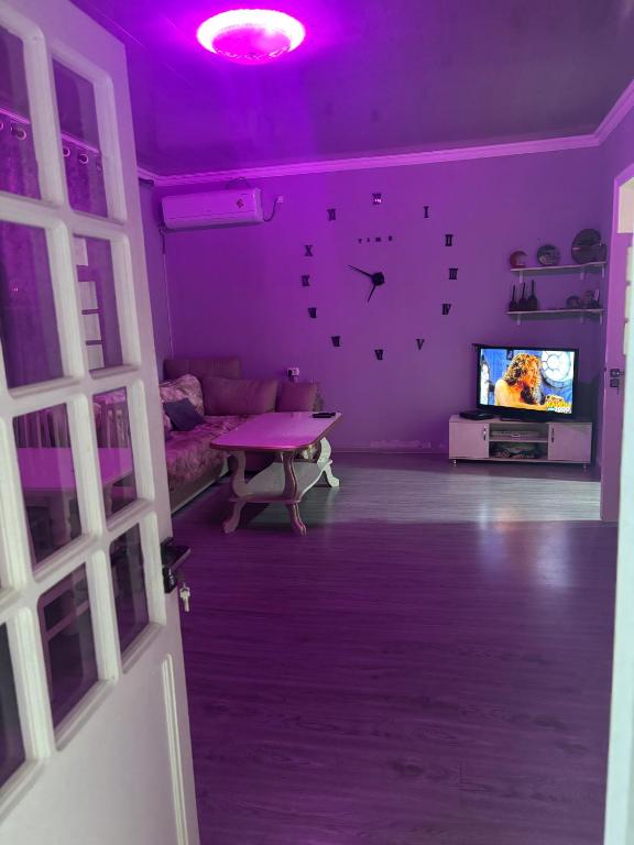 a living room with a purple ceiling and a tv at Домик Zara in Samarkand