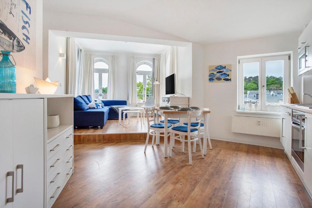 een keuken en woonkamer met een tafel en stoelen bij Villa Sonneck Appartement 20 in Ostseebad Sellin