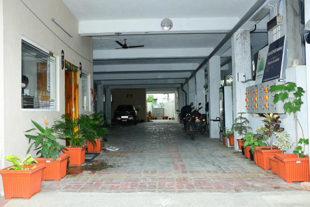 a hallway of a building with potted plants at Sri KASTHURI Residency in Tiruttani