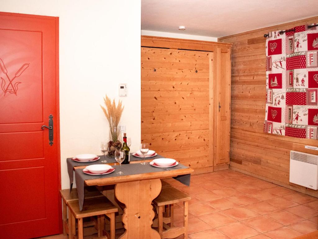 a dining room with a table and a red door at Studio cabine 6 personnes avec balcon, parking et casier à ski - FR-1-504-124 in Uvernet-Fours