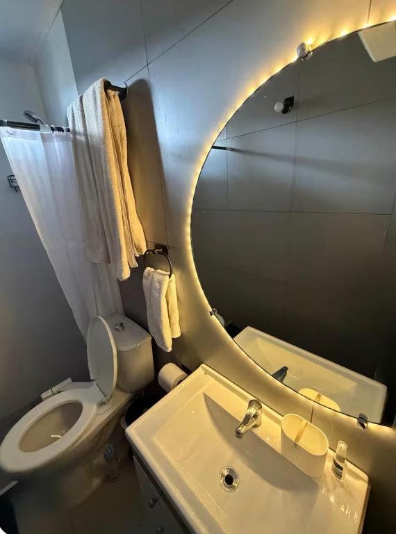 ein Badezimmer mit Toilette, Waschbecken und Spiegel in der Unterkunft Casa en Maldonado in Maldonado