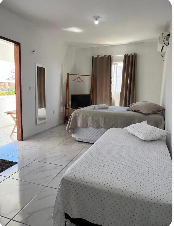 a bedroom with two beds in a room at Apartamento da Kenia in Canoa Quebrada
