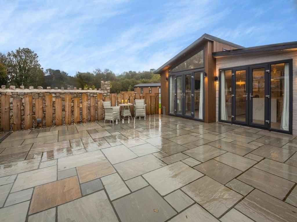 a large outdoor patio with a wooden fence at Sandbanks 2 bed Lodge with hot tub - L1 in Brynteg