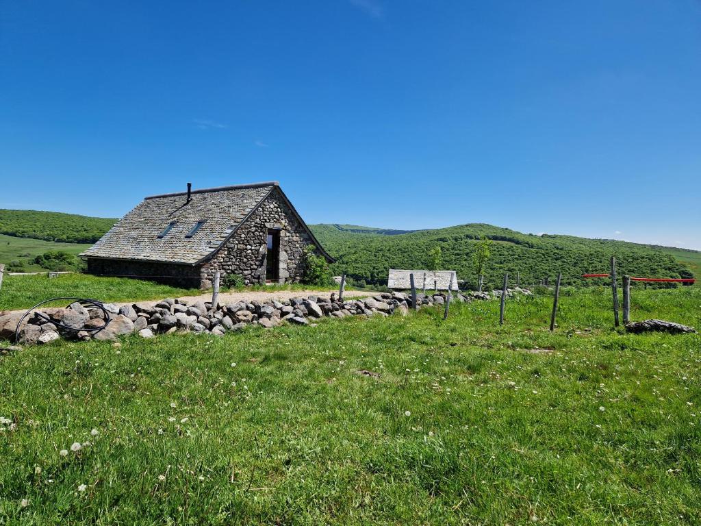 an old stone barn in a field of grass at Buron de Léon, en plein cœur de l Aubrac in Laguiole