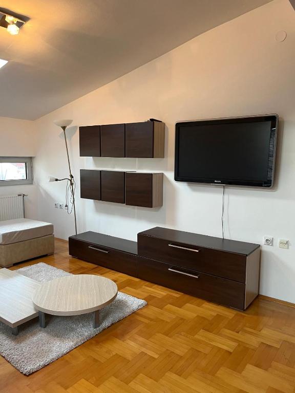 Una sala de estar con un televisor de pantalla plana en la pared. en Apartman Luka, en Niš