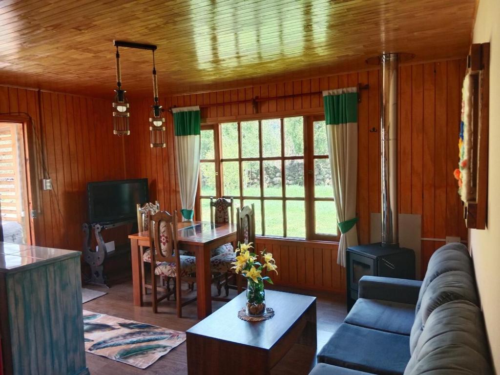 ein Wohnzimmer mit Sofa und Tisch in der Unterkunft Pircas de Rucalhue Cabins for 4 people and Jacuzzi in Quilaco