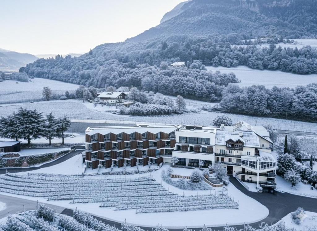 un hotel con nieve en el suelo frente a una montaña en Hotel Tenz, en Montagna