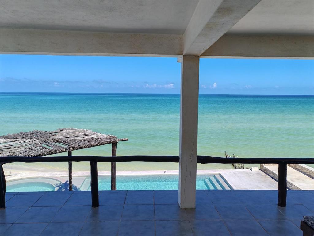 - une vue sur l'océan depuis la terrasse dotée d'un parasol dans l'établissement Beach Villa Seaside Sunset Haven Nature & Chill, à Chuburná