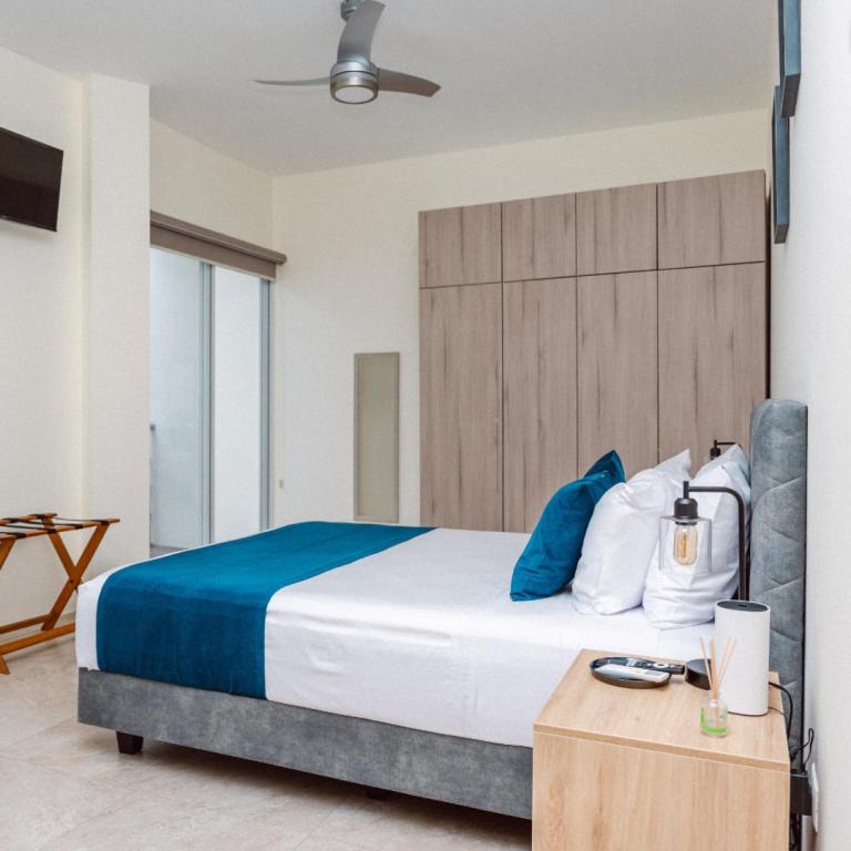 une chambre avec un grand lit avec une couverture bleue dans l'établissement Casa Orilla Lodge, à Huamboya