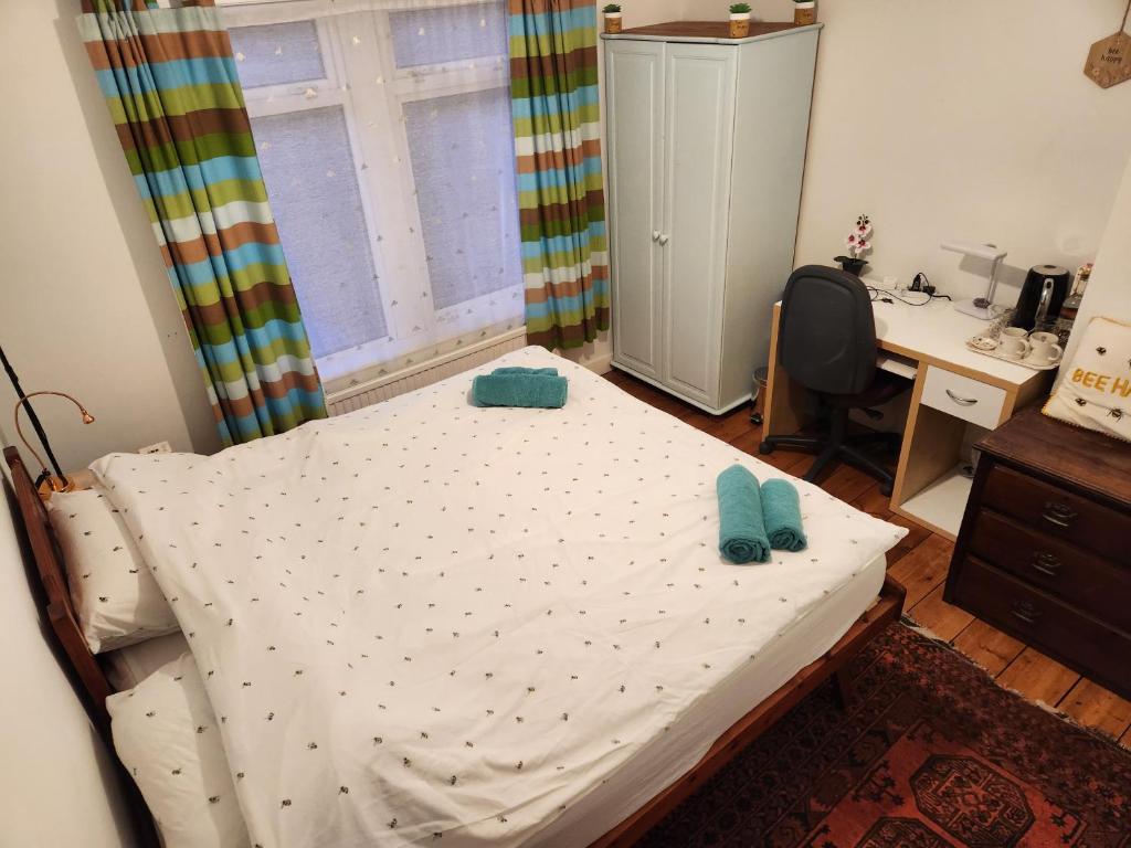 a bedroom with a bed and a desk and a window at BEE GENTLE BEE KIND BEE HAPPY rooms in Glastonbury