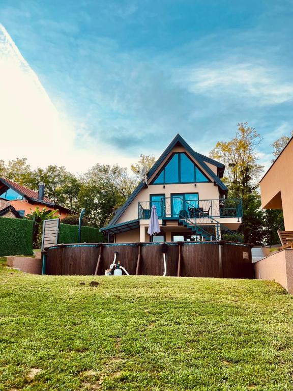 a dog laying on the grass in front of a house at Melody in Kapela