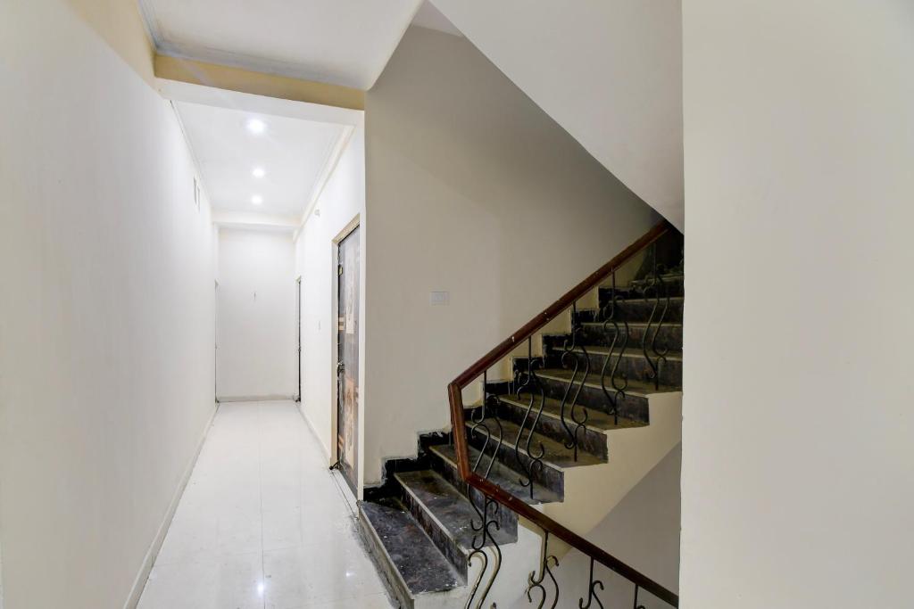 a staircase in a white building with a stair case at SPOT ON The Royal Inn in Kakarmatha