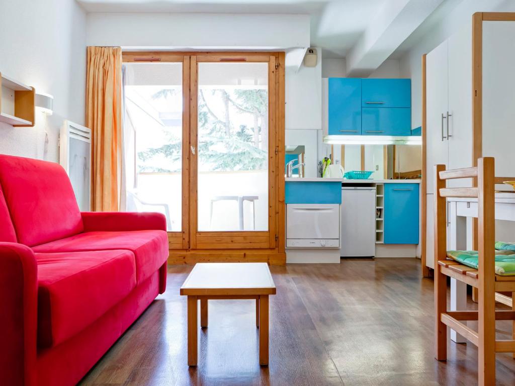 ein Wohnzimmer mit einem roten Sofa und einem roten Tisch in der Unterkunft Studio 2* Brides-les-Bains avec WIFI, 4 personnes - FR-1-512-141 in Brides-les-Bains