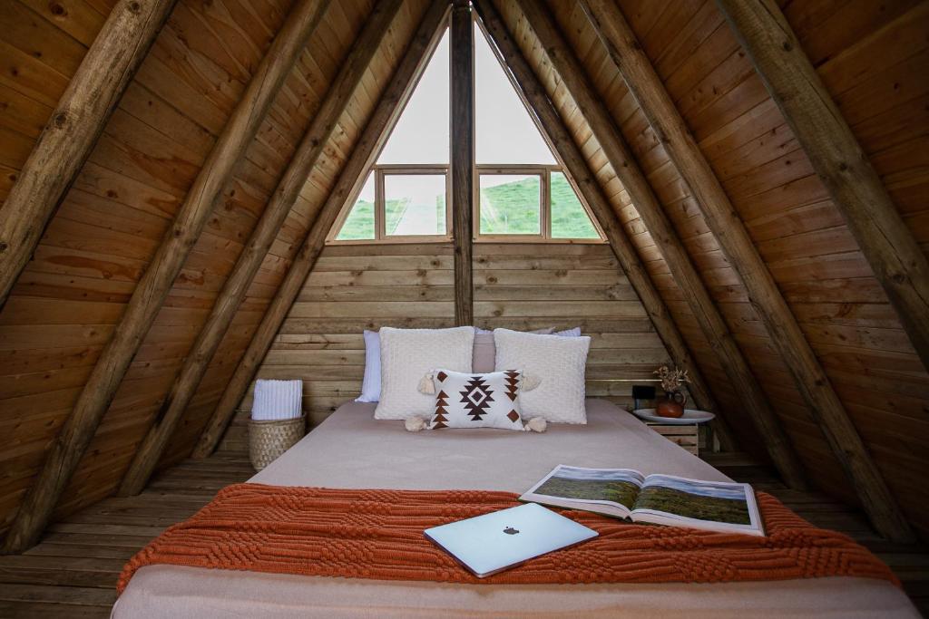 una cama en una habitación con una ventana grande en Cabañas con jacuzzi y chimenea - Casa Floral, Marinilla, en Marinilla