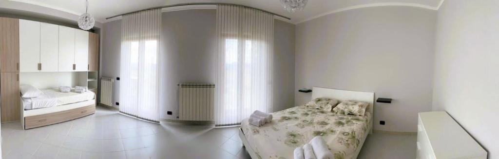 Cette chambre blanche comprend un lit et un miroir. dans l'établissement Respiro di luna, à Pescopagano