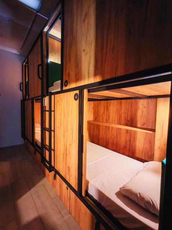 a wooden room with two bunk beds in it at Capsule Inn Madrid in Madrid