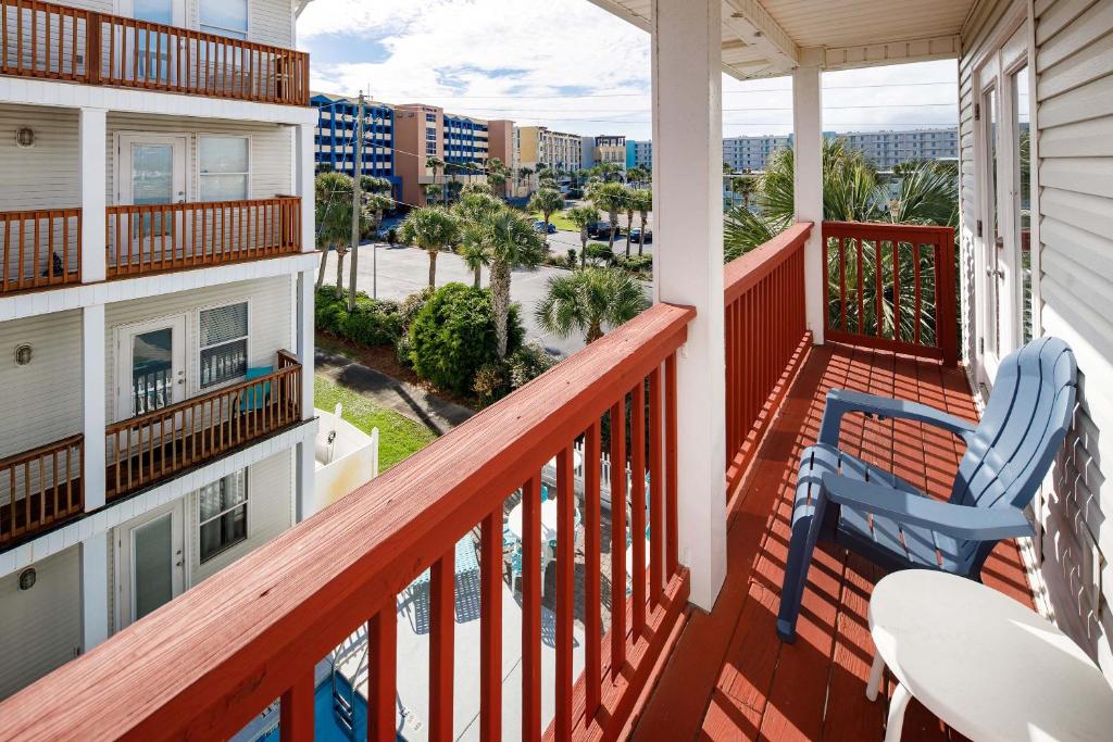een balkon met 2 stoelen en uitzicht op een straat bij Sunset Cottages 1C Pet friendly cottage in Fort Walton Beach