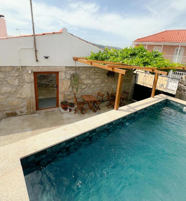 a house with a swimming pool and a table with plants at JUNKEIRA - Casa, Douro e Campo in Junqueira