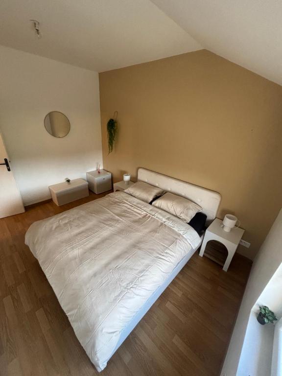 1 Schlafzimmer mit einem großen weißen Bett und 2 Tischen in der Unterkunft Room New Zealand in Le Quesnoy
