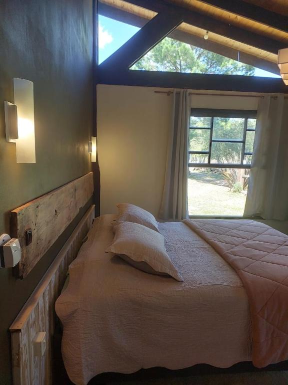 a bedroom with a bed with pillows and a window at Vale das Águas in Cambará