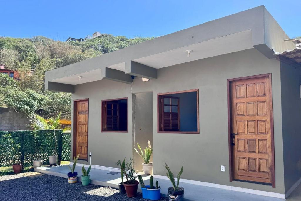 una casa con dos puertas y macetas en Estúdios Sol e Mar, aconchego e charme em Tucuns, en Búzios