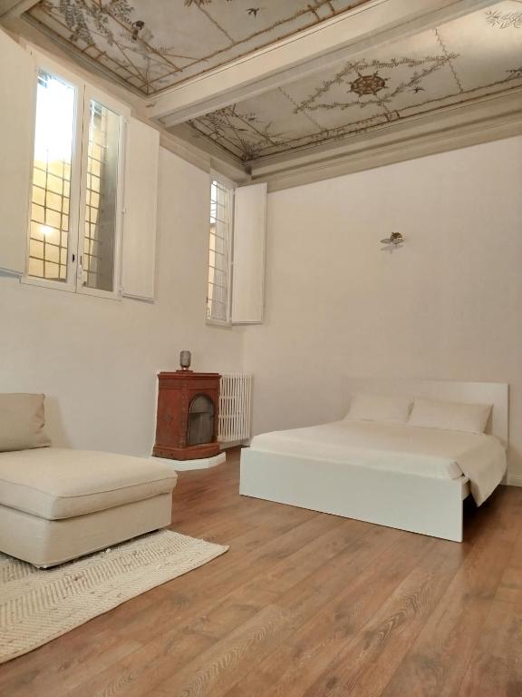 a white room with two beds and a fireplace at A Casa di Mavina - Luxury Stay in Siena