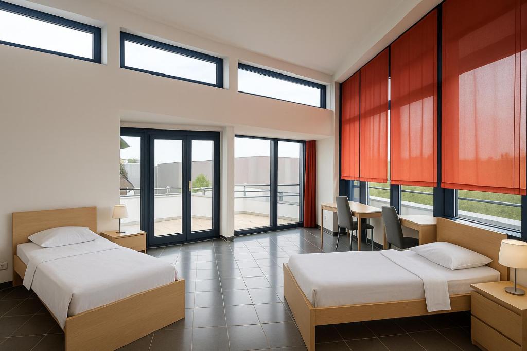 - 2 lits dans une chambre avec de grandes fenêtres dans l'établissement Monteur- und Ferienunterkunft Ludwigsfelde, à Ludwigsfelde