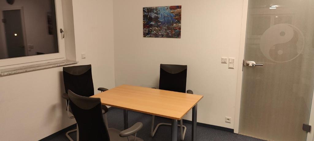 ein Konferenzraum mit einem Holztisch und Stühlen in der Unterkunft Family Room Grüne Auszeit Dresden in Dresden