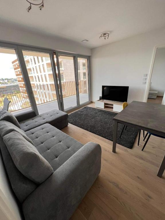 a living room with a couch and a table at Cloche d Or modern 2 bed in Luxembourg