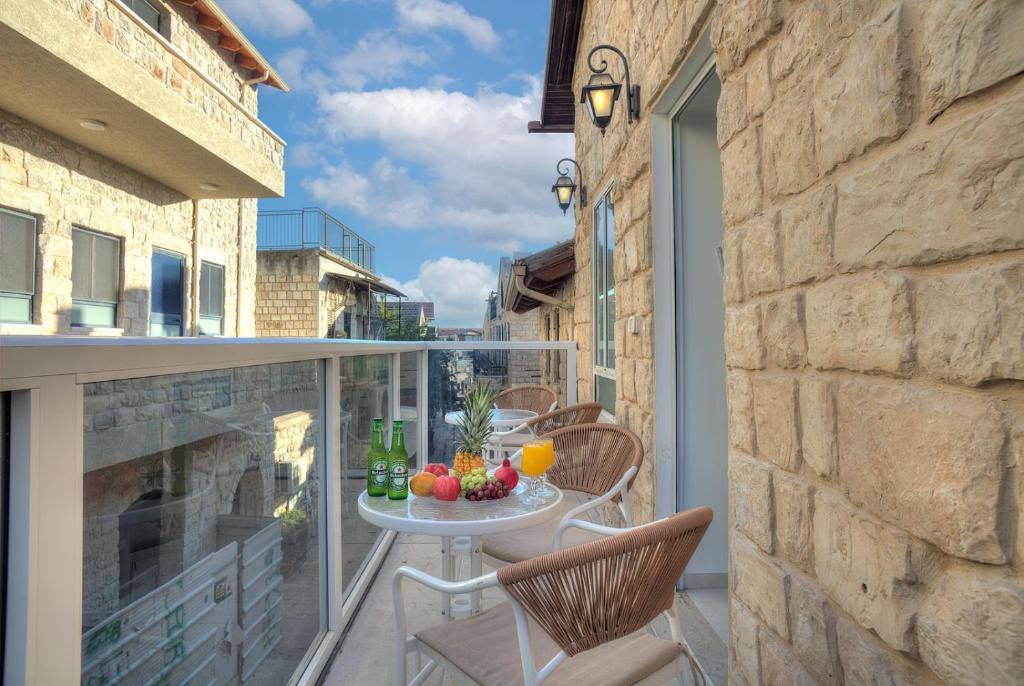 Un balcón con una mesa con fruta encima. en Mountain Top Views -203- נופי פסגות, en Safed