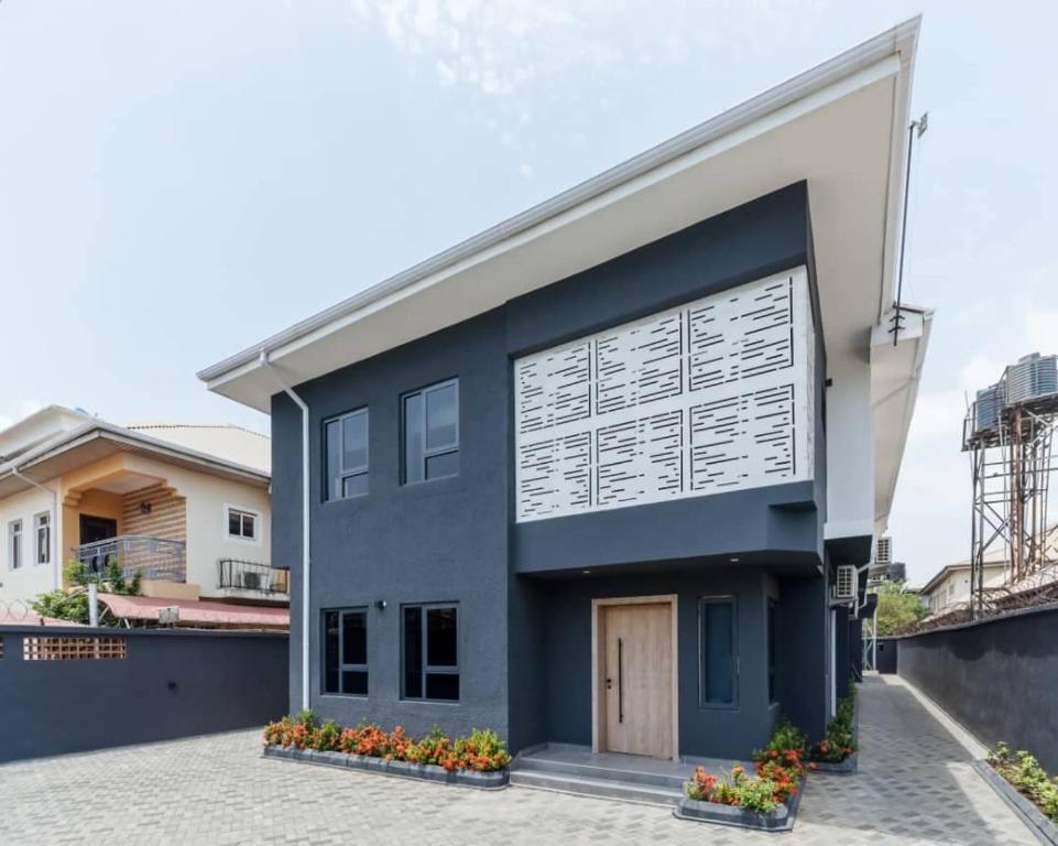 una casa con una fachada azul y blanca en The Urbanest, en Lagos