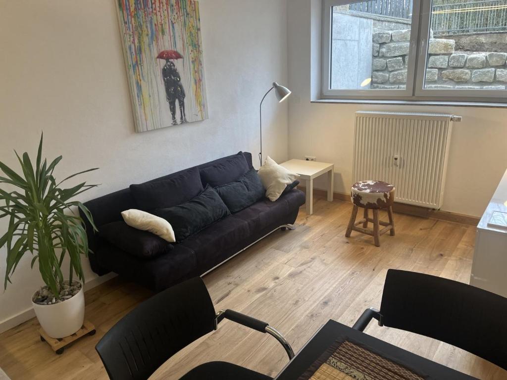 un salon avec un canapé noir et une table dans l'établissement Studio Birkental, à Veitshöchheim