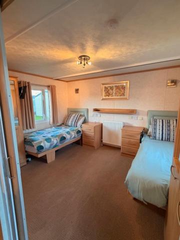 a bedroom with two beds and a sink in it at Caravan Wendy 2 Bed Adapted Caravan in Meliden