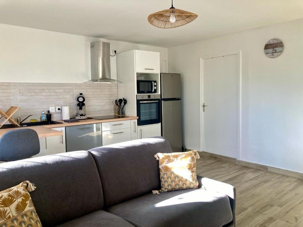 a living room with a couch and a kitchen at Ti Zeinga la in Sainte-Anne