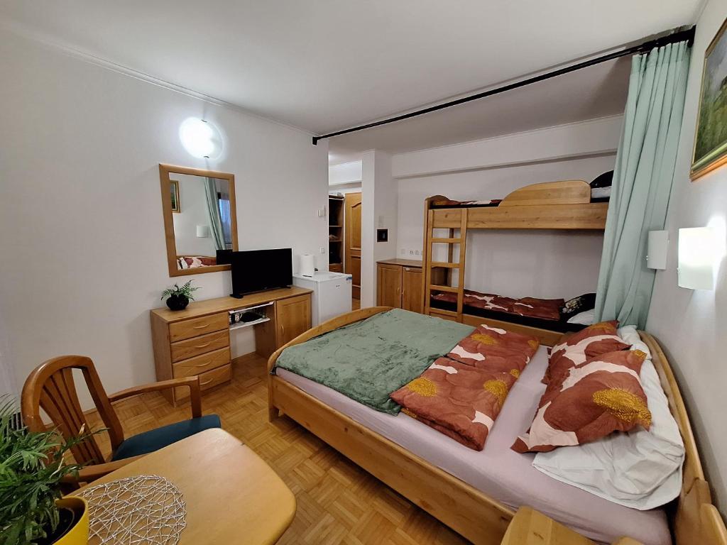 ein Schlafzimmer mit einem Bett, einem Tisch und einem Schreibtisch in der Unterkunft Mia's room in Zreče