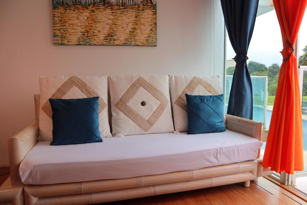 un sofá con almohadas azules en la sala de estar. en Oceanfront Studio Beach and Pool, en María Chiquita