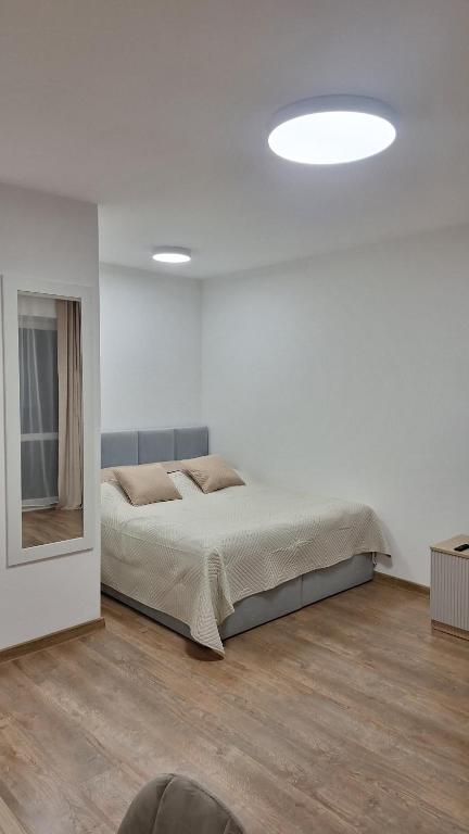 a white bedroom with a bed and a mirror at Mieszkanie Armii Krajowej kawalerka basen centrum in Nowy Sącz