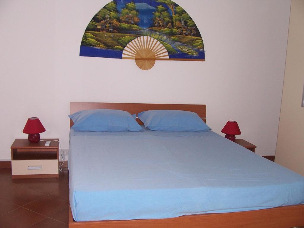 ein Schlafzimmer mit einem Bett und einem Gemälde an der Wand in der Unterkunft Casa Fortuna in Il Monte