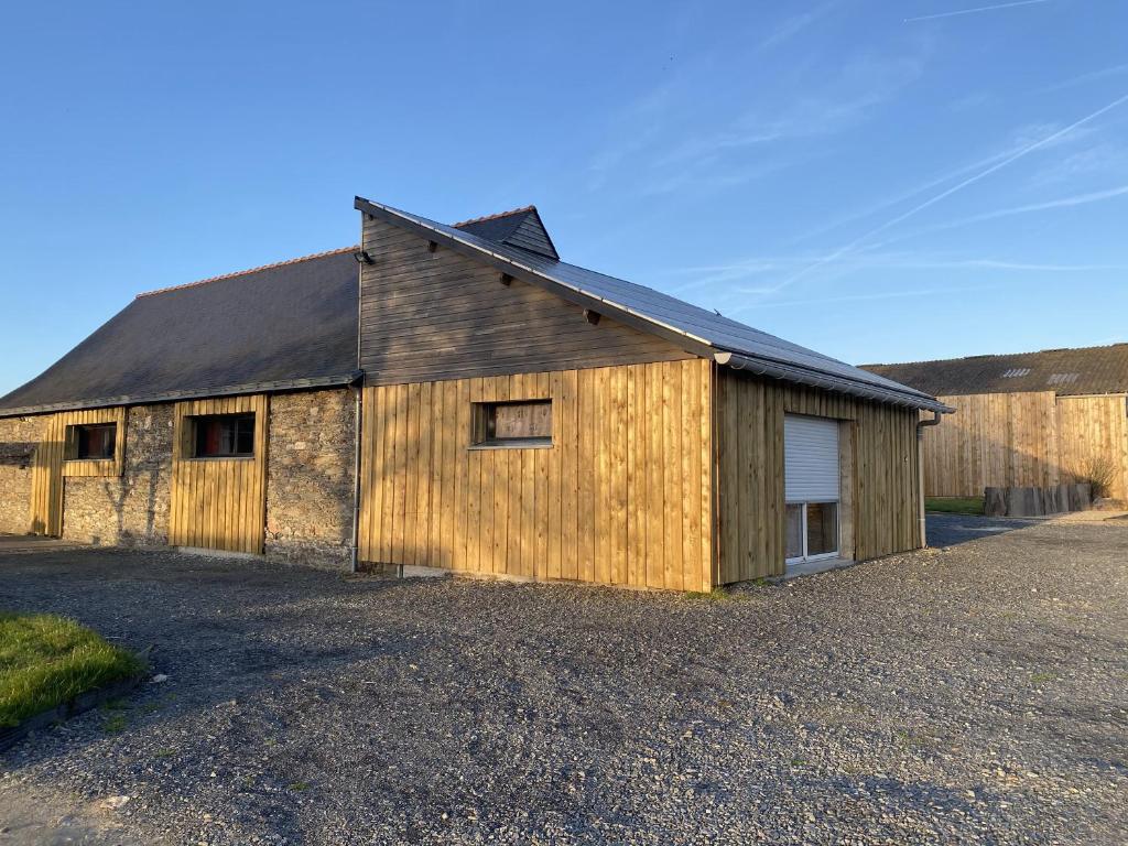 un ancien bâtiment en bois avec un garage dans l'établissement Le Nid, à Abbaretz