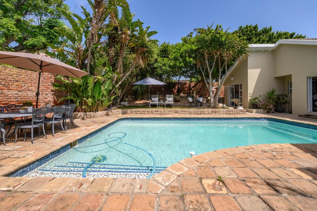uma piscina em um quintal com mesa e cadeiras em Keiskama B & B em Port Elizabeth