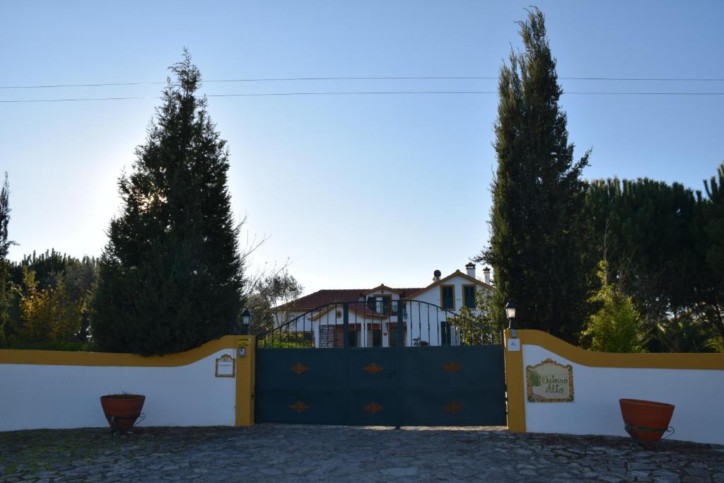 una puerta azul con dos árboles delante de una casa en Quinta do Outeiro Alto en Constância