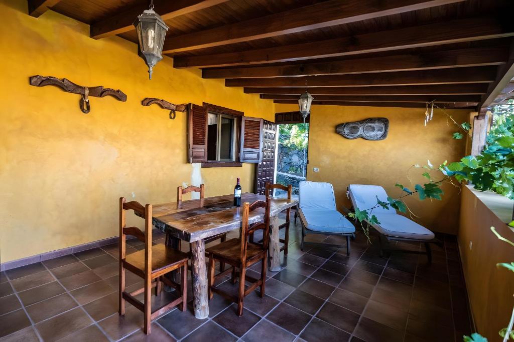 a dining room with a wooden table and chairs at Casa Tajonaje in Alajeró