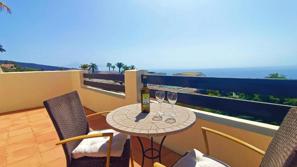 a balcony with a table and two glasses of wine at Casa Micaela - Exclusive in Playa de Santiago