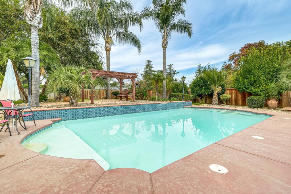 a swimming pool with a gazebo and palm trees at Outdoor Kitchen & Patio! Central Valley Hacienda in Atwater