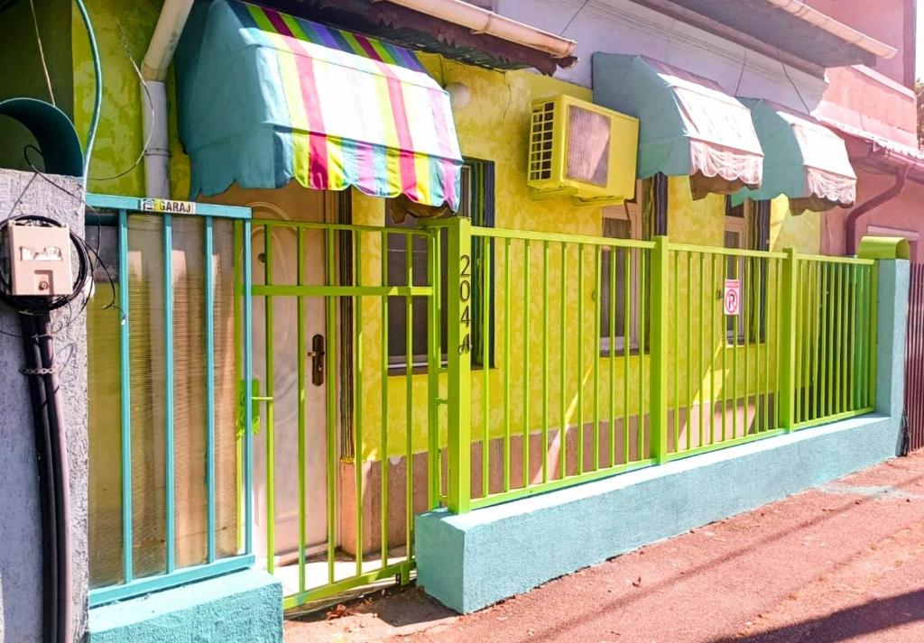 un portail vert sur le côté d'un bâtiment dans l'établissement Artsy entire House, fully equipped, 2 rooms, 2 beds, parking, all to yourself!, à Bucarest