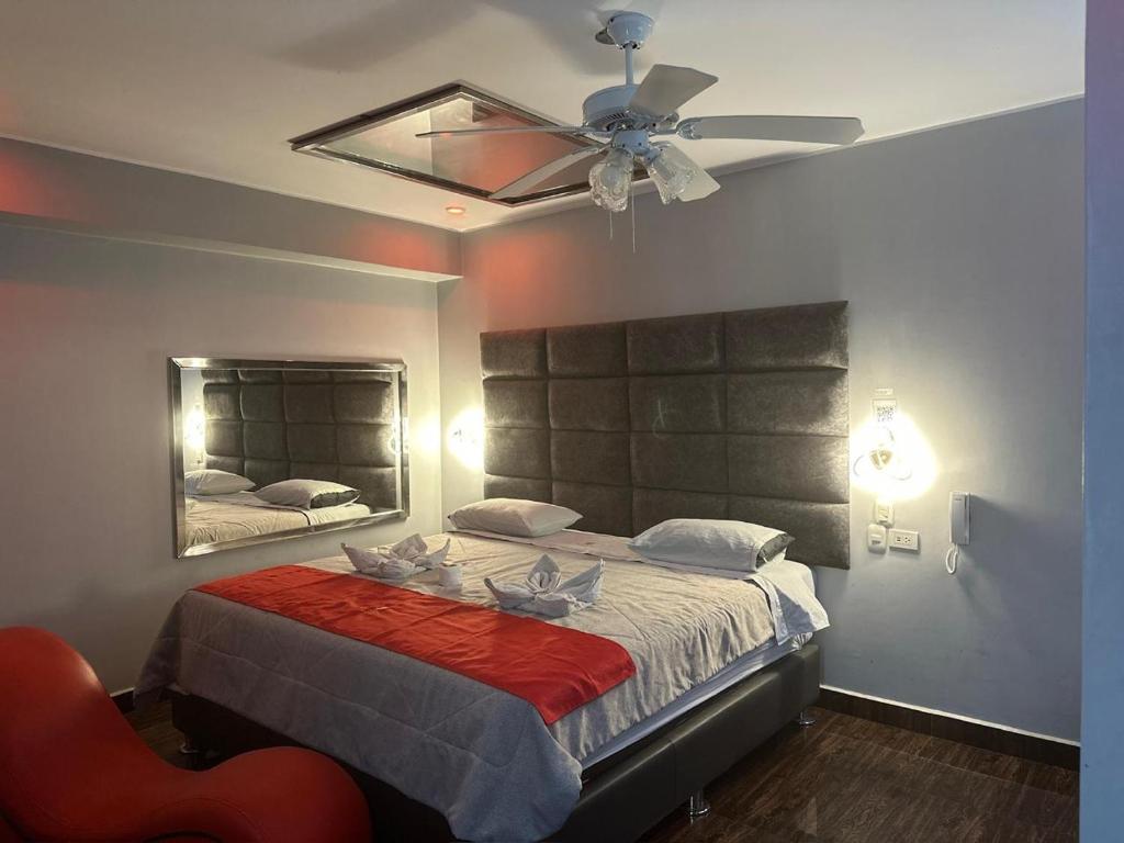 a bedroom with a bed with a ceiling fan at Hotel Hyds in Lima