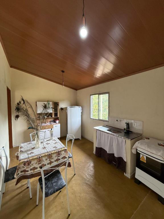 eine Küche mit einem Tisch und einem Kühlschrank im Zimmer in der Unterkunft Recanto Zechini in Vargem Alta