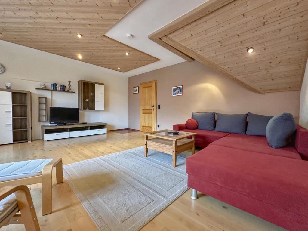 a living room with a red couch and a tv at Riedenburg I in Buch